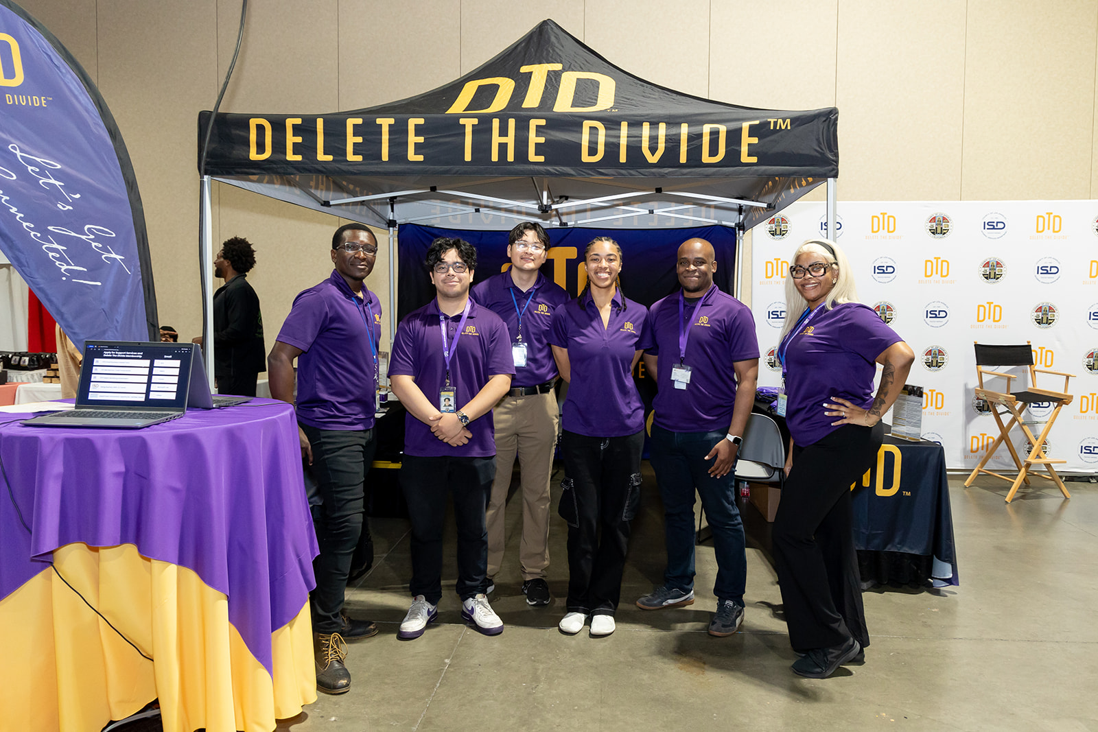 Group photo of the DTD crew standing Infront of their booth at the Women's Health Expo