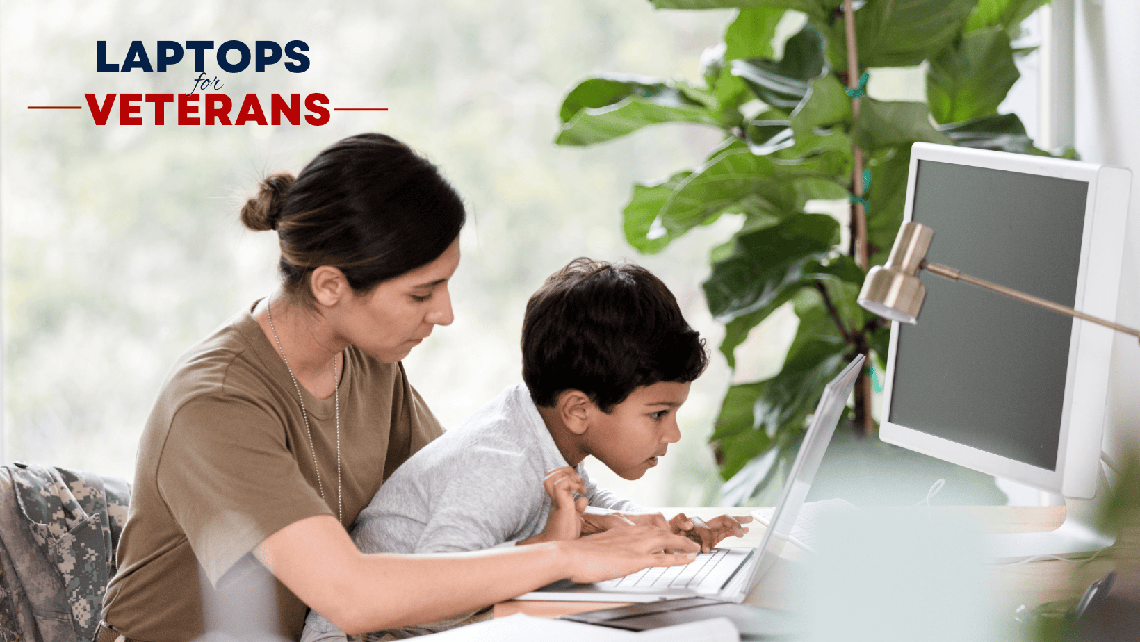 veteran and boy using a laptop together