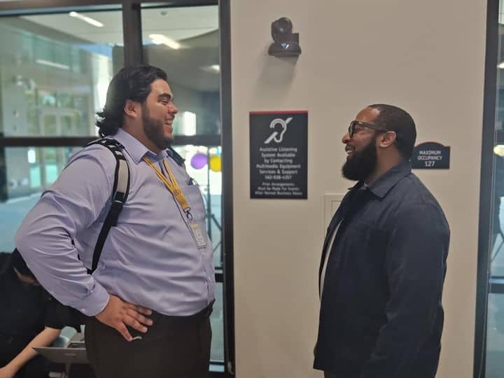 Intern and man in suit talking to each other.