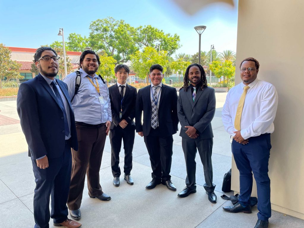 male interns in suits standing