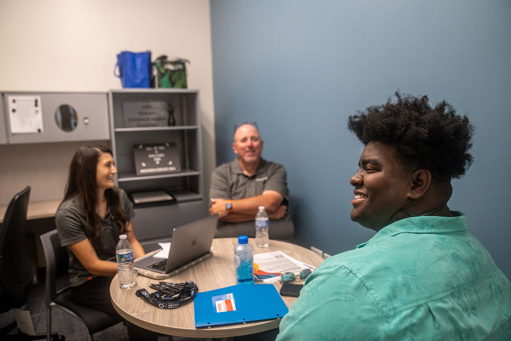 An intern smiling looking away from two job recruiters