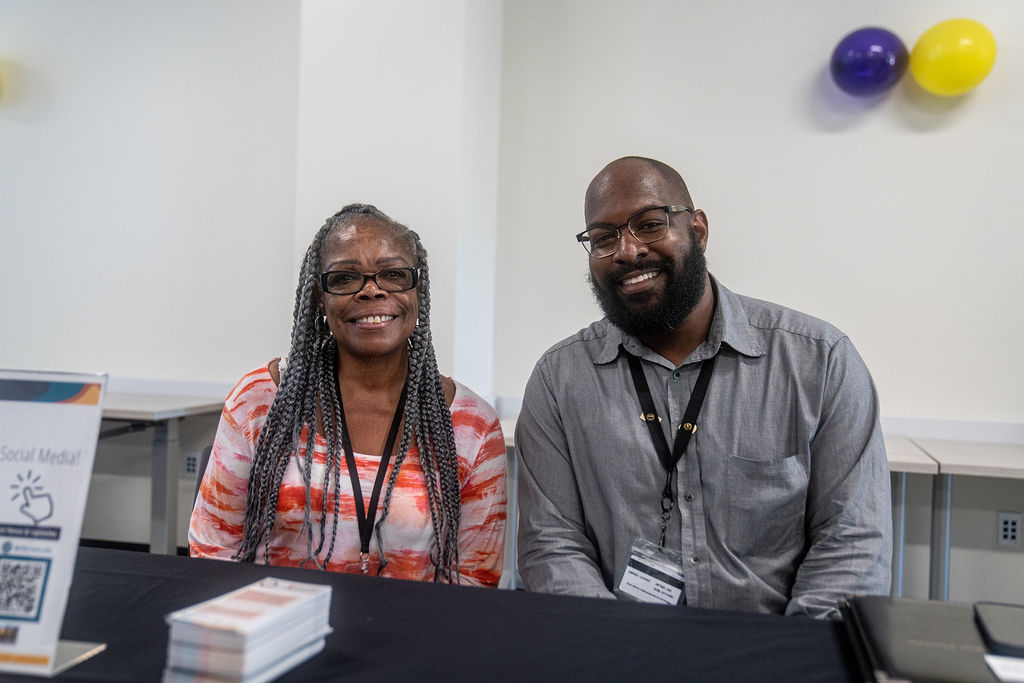 A man and a woman sitting side by side smiling