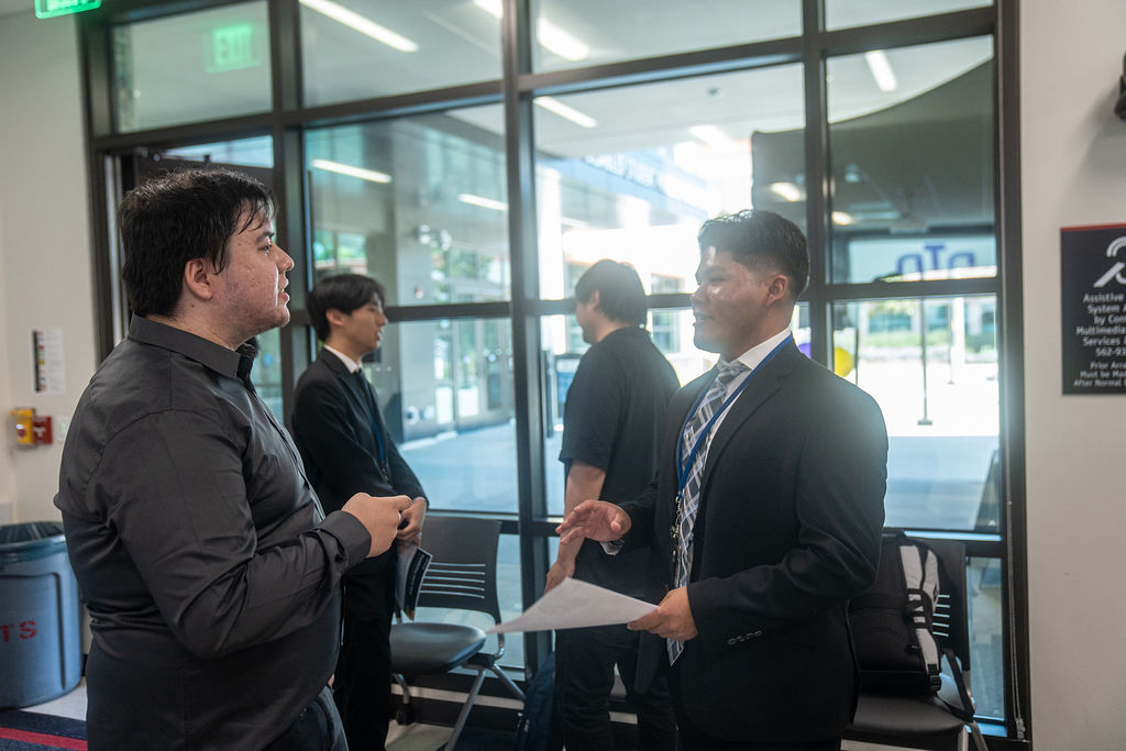 Two men in formal attire talking.