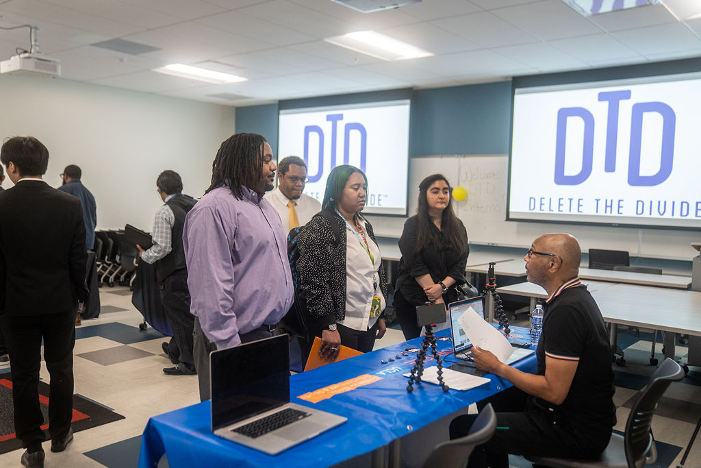 Three interns being informed by a job recruiter.